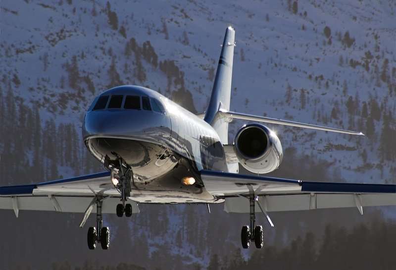 Falcon 2000EX Lannding on Runway with Snowy Mountains in the Background | Stratos Jets Charters, Inc.