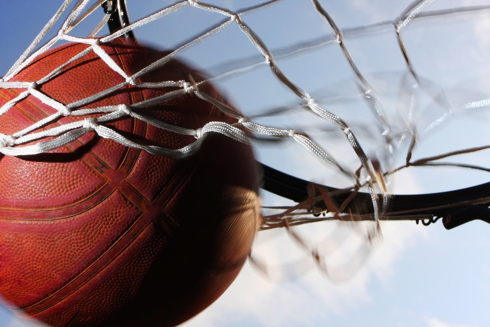 A basketball swishes through the net.