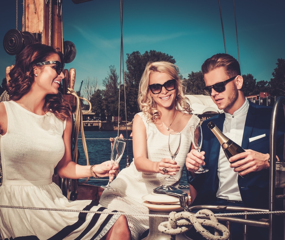 A young and stylish group of friends drinking champagne on a yacht.
