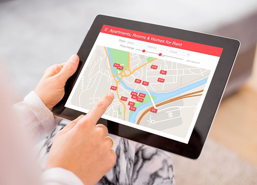 A person looking for a rental place on a tablet