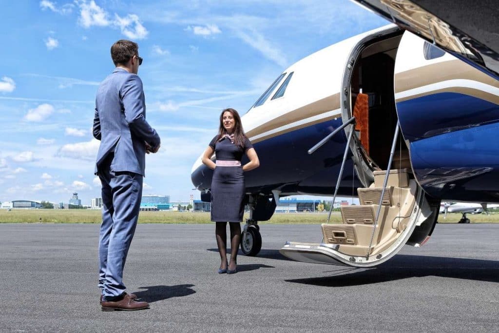 man boarding private jet with flight attendant
