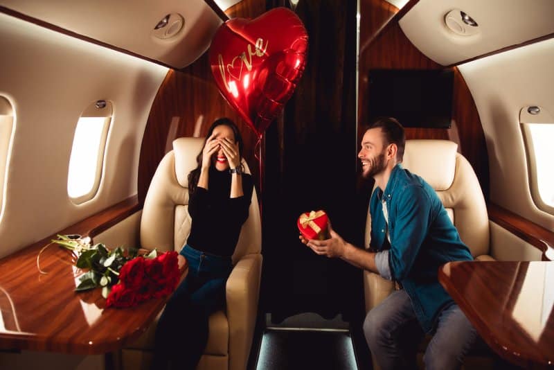 A couple on a private plane celebrating a romantic moment.