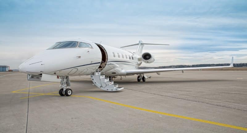 A business jet parked and waiting for passengers to board.