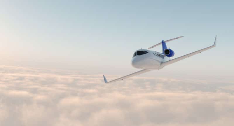 A light jet banking above the clouds.