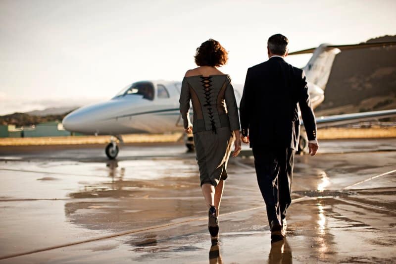 A power couple walking toward a private jet.