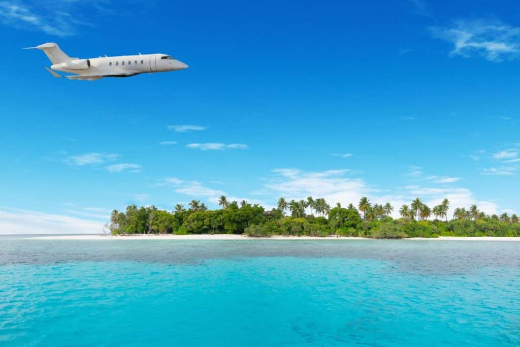 A private plane flying above a tropical island.