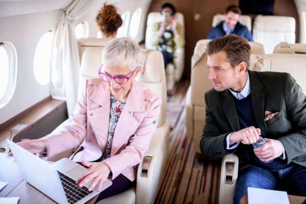 Business people using private jet Wi-Fi