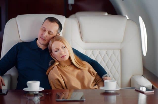 A couple takes a nap during a private charter jet flight.