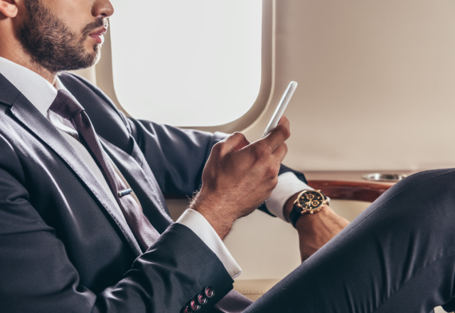 A man wearing a suit sitting in a private jet