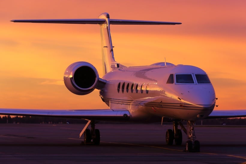 A private jet on the runway at sunset