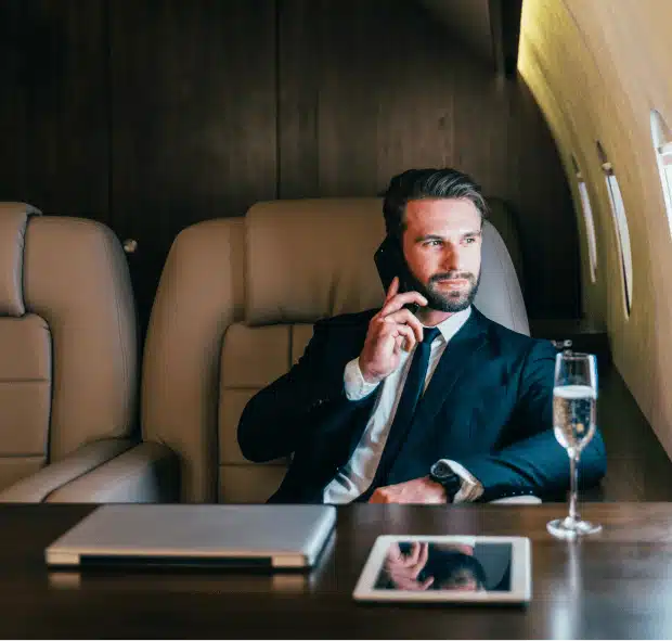 Man in Suit on Cell Phone While on Private Jet Flight | Stratos Jets