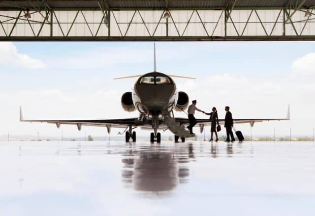 A private jet in a hangar with passengers boarding
