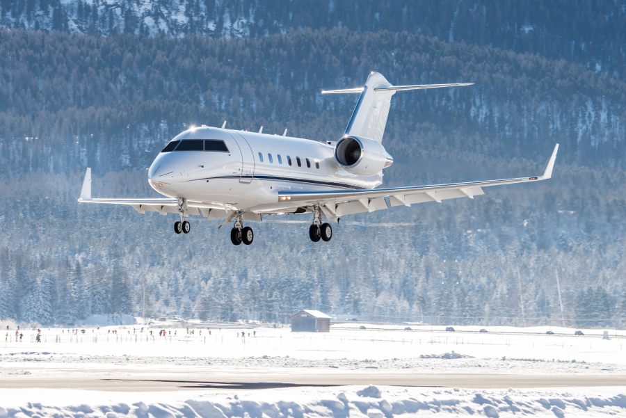 A private jet approaches the runway of a snowy airfield