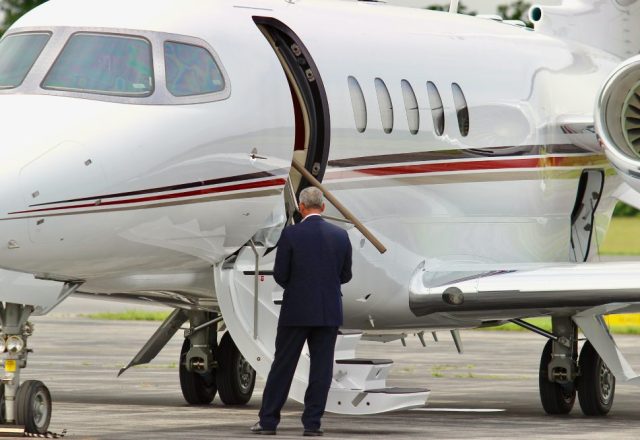 A businessman standing by the stairs of his private jet