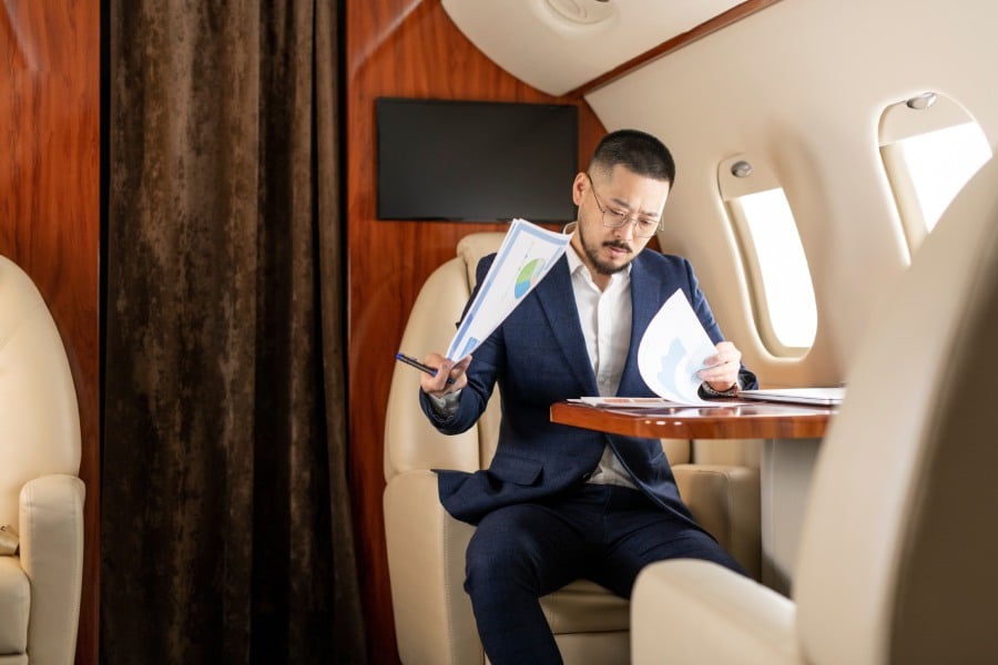 A businessman reviews important documents on a private jet