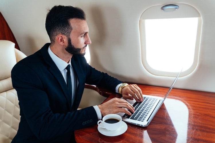 Businessman using laptop on a private jet