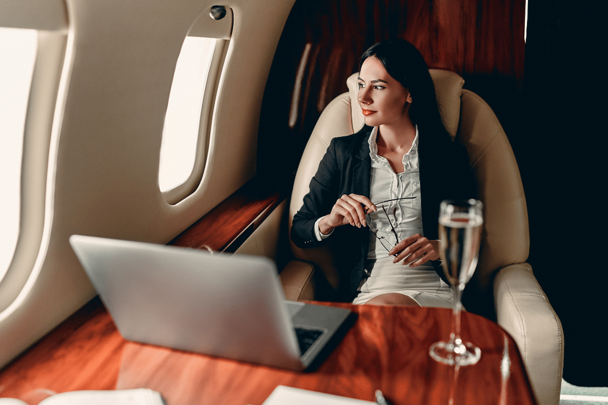 A woman enjoys champagne on a private jet