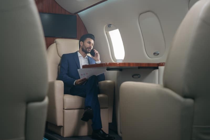 A private jet passenger makes a phone call while in the air.