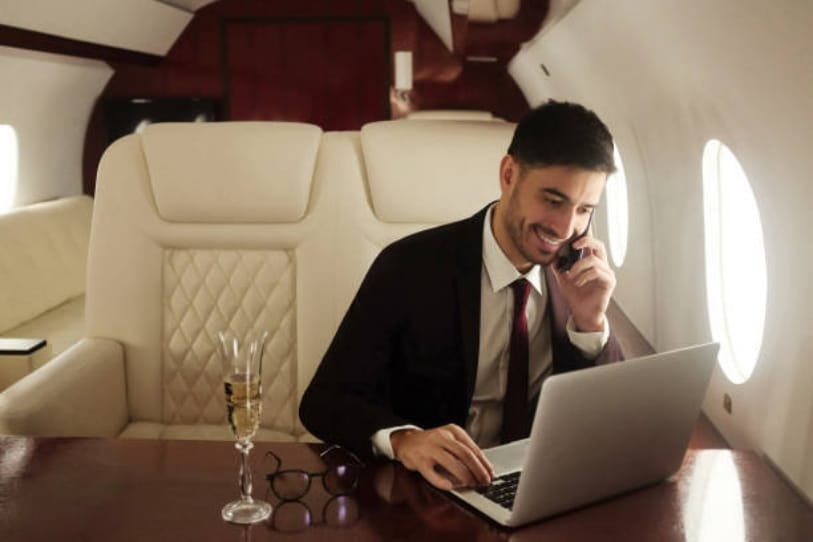 Business man on a private jet with a laptop