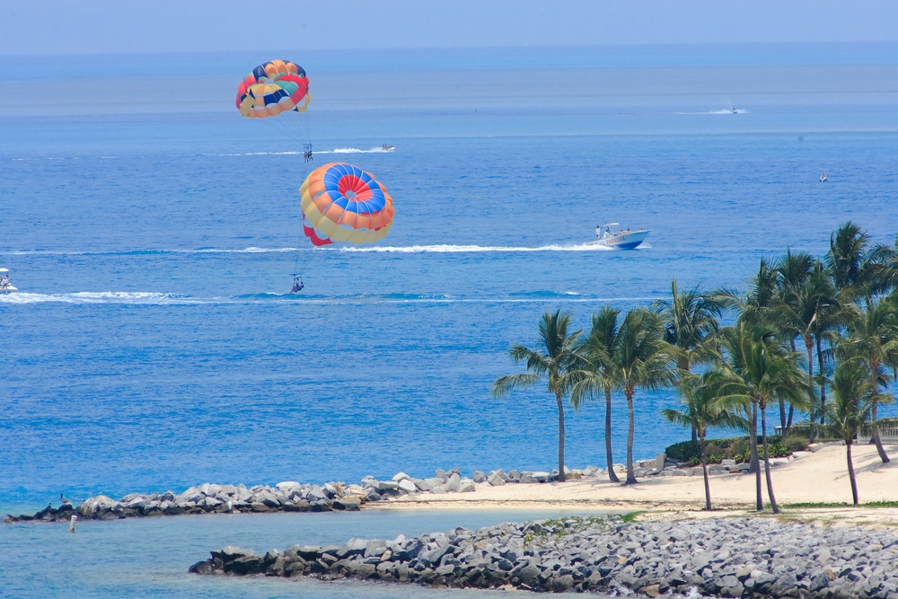 Two bright parachutes float gently to the sandy shores of Key West, Florida.