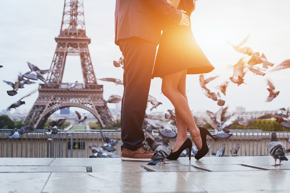 A couple celebrates their love in front of the Eiffel Tower.