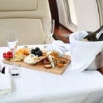 A plate of delicious food and champagne on board a private jet.