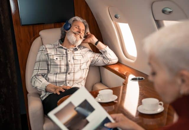 An older couple relaxes aboard a private jet charter.
