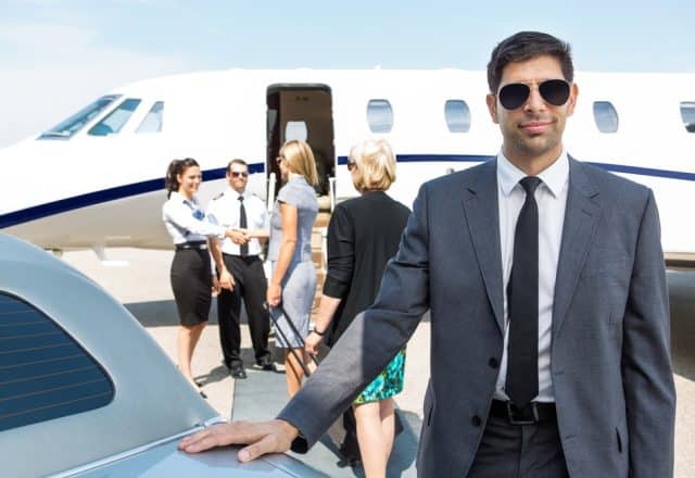 A portrait of a confident businessman in a suite getting ready to board a private jet.