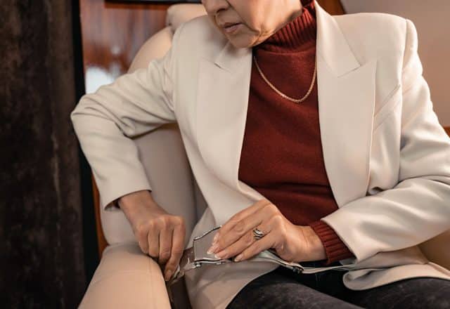 A woman on a private jet fastening her seatbelt
