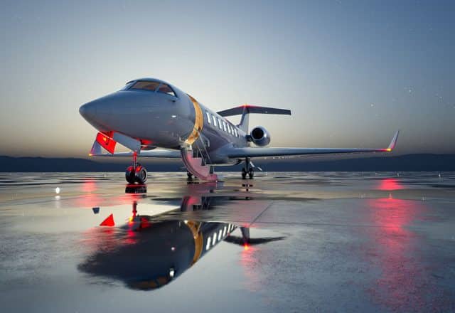 A private jet waits to depart on a runway.