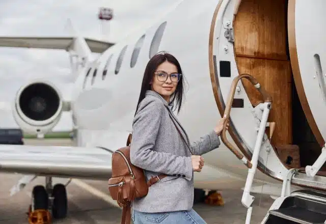 A woman boards a private jet before takeoff.