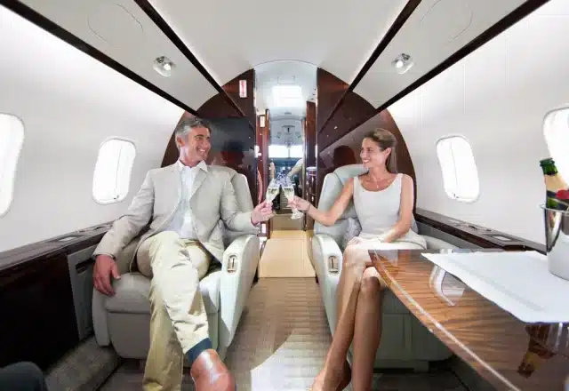 A happy couple sharing champagne on a private jet