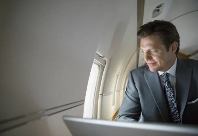 A corporate man looking out of a private jet window
