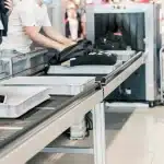 A luggage x-ray machine in an airport security line.