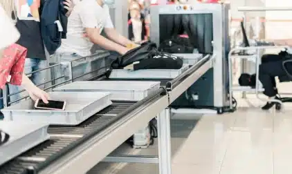 A luggage x-ray machine in an airport security line.