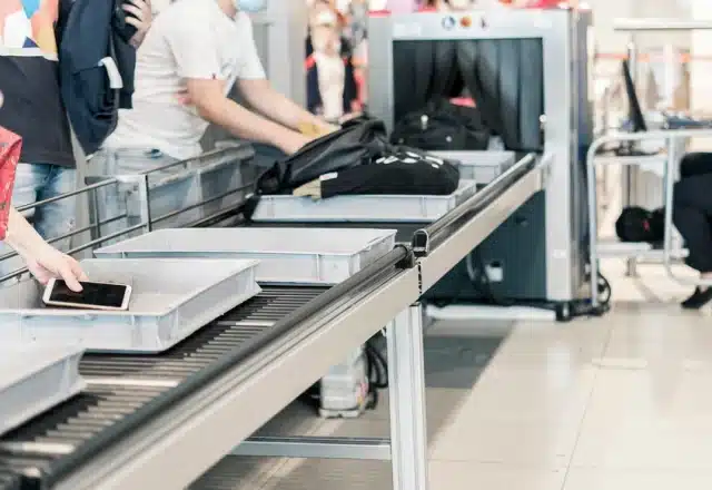 A luggage x-ray machine in an airport security line.