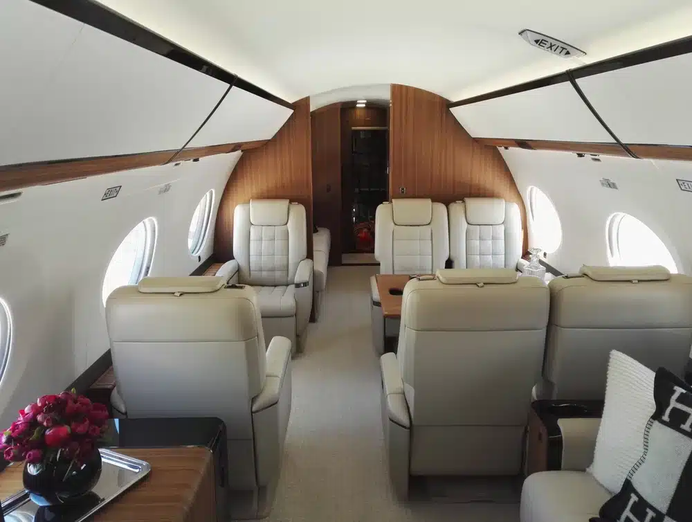 The cabin of a luxury jet with six seats visible.