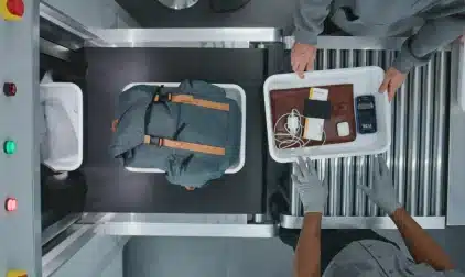 A top-down view of luggage going through a x-ray machine.