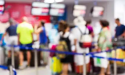 A soft focus view of a long TSA line in an airport.